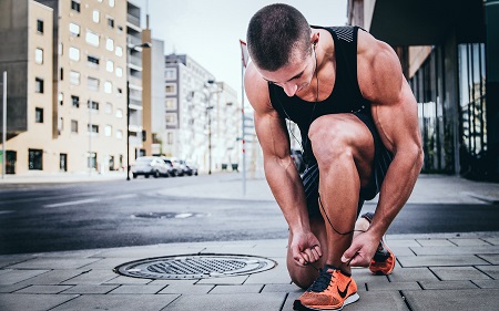 Athletic man tying shoe